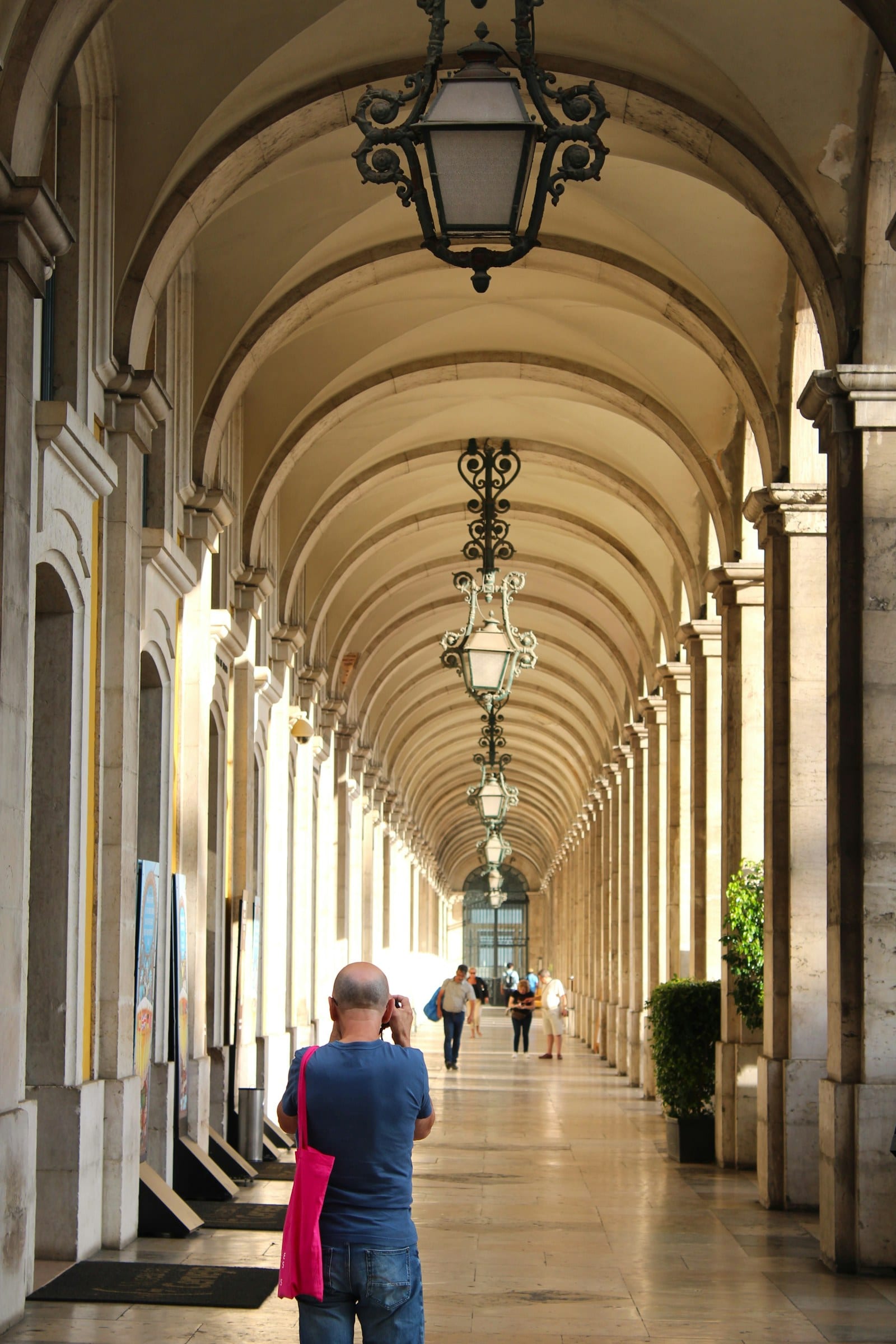 A long vaulted arcade in Lisbon with a figure walking through it
