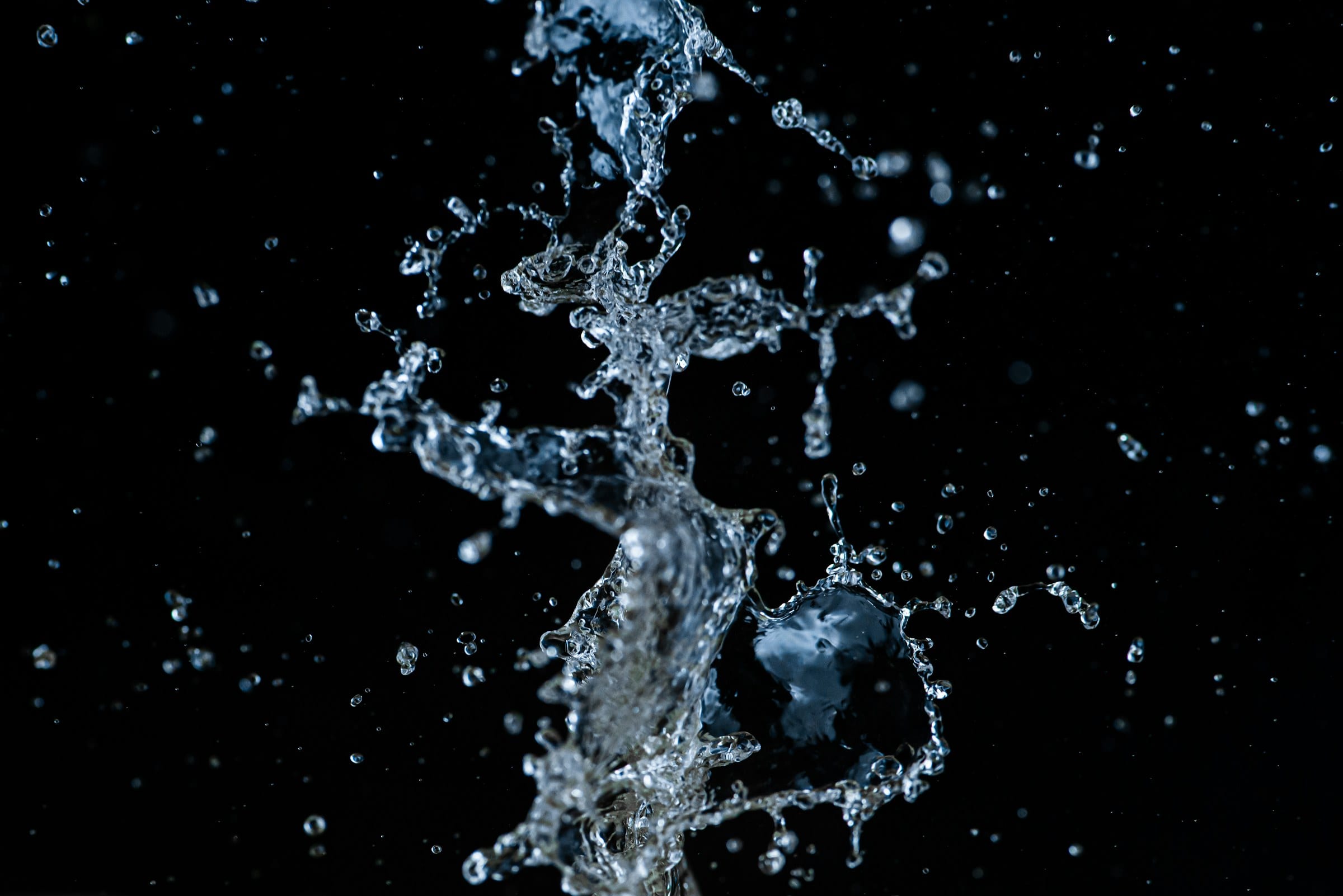 Water exploding into droplets against a black background