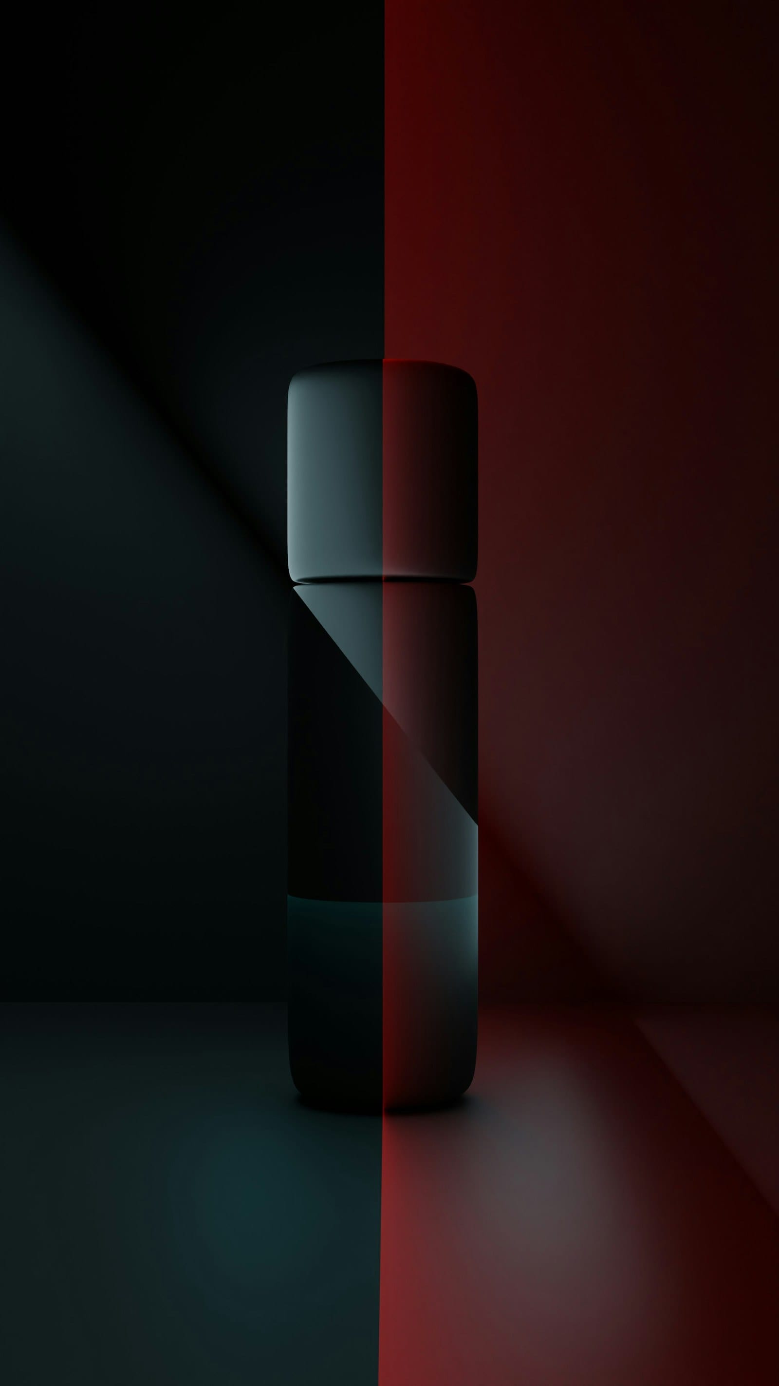 A dark, unlabelled bottle split down the middle by red and teal light